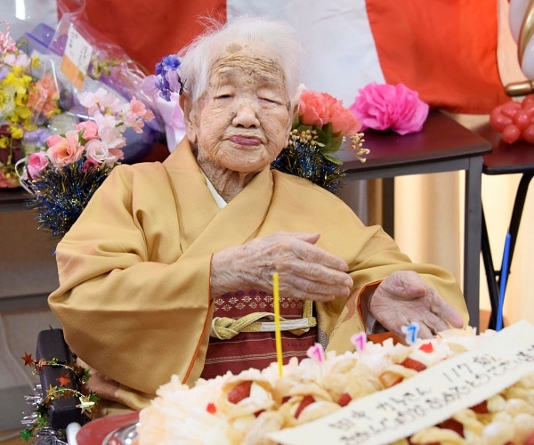 kane tanaka sits with birthday cake